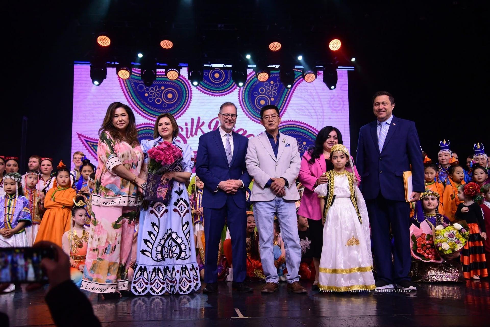 Adults and children gathered on a colorful performance stage